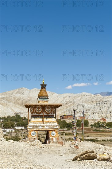 Colourfully decorated Buddhist stupa at the entrance to the village