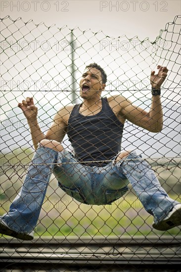 Young man climbing a fence