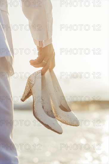 Man holding white stiletto shoes