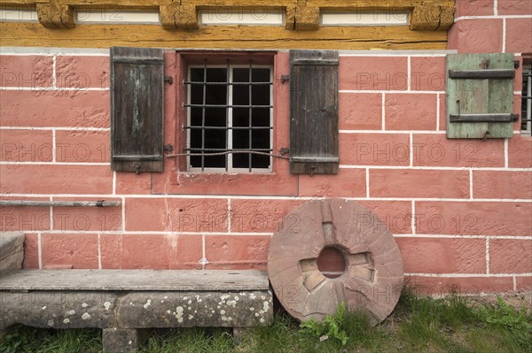 Millstone leaning against an old flour mill