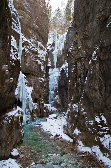 Icy gorge with a mountain stream and steep rock walls