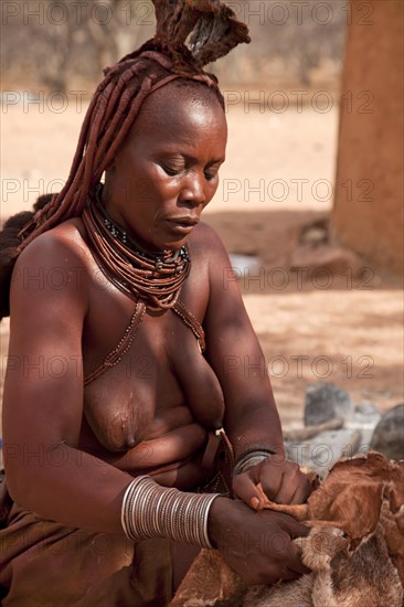 Woman from the tribe of the Himba wearing traditional clothes in a village near Kamanjab