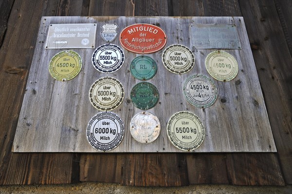 Panel with award plaques for milk yield on a cowshed