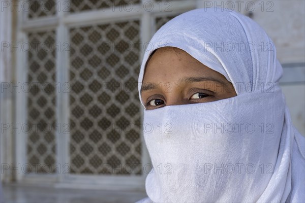 A portrait of a young veiled Muslim woman visiting the Bibi Ka Maqbara