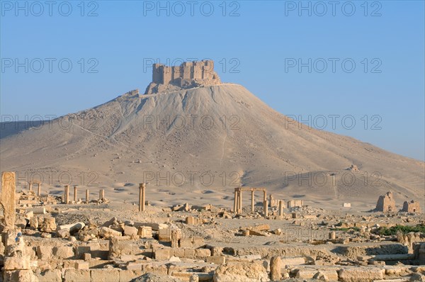 The ruins of the ancient city Palmyra in front of a medieval fortress