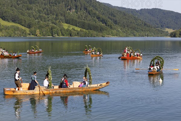 Locals wearing traditional costumes in decorated wooden Platte boats