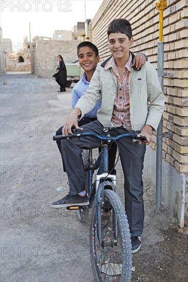 Boys with a bicycle in a residential alleyway