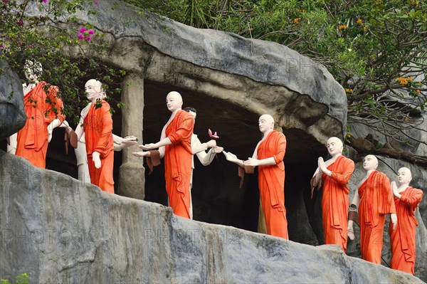 Figures of Buddhist monks in front of a rock niche at the Golden Temple