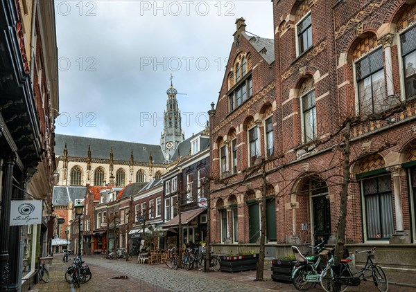 Warmoesstraat street in the old town with view of the church tower of Sint-Bavokerk Cathedral