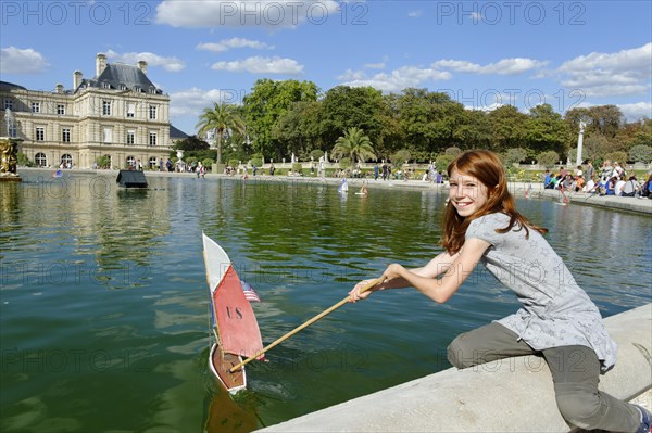 Girl playing with ship at the pond of the Palais du Luxembourg