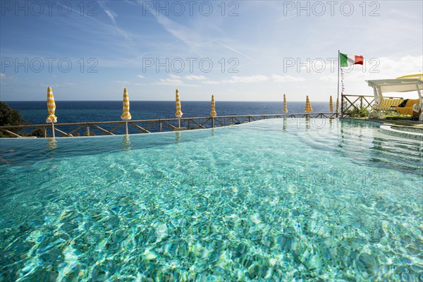 Swimming pool and the Mediterranean with the flag of Italy