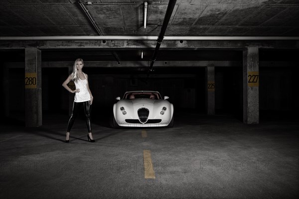 Woman standing next to a white sports car