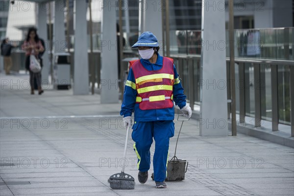 Female street cleaner wearing a safety vest