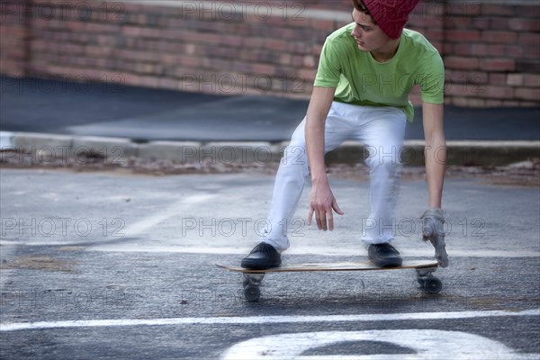 Teenager riding a longboard on a wet street