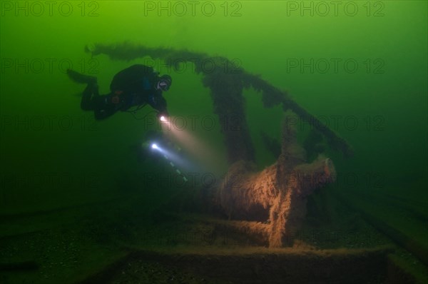 Diver inspects the pump of a shipwreck