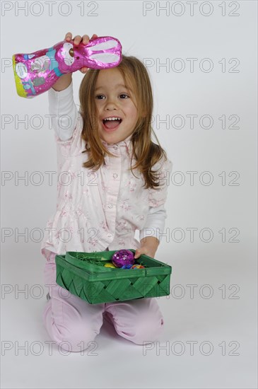 Girl is happy about an Easter basket and a chocolate Easter bunny