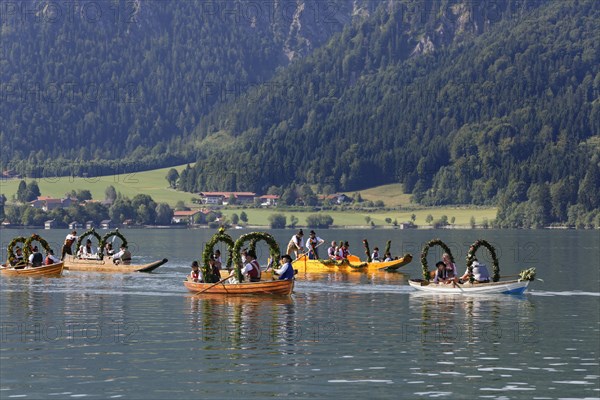 Locals wearing traditional costumes in decorated wooden Platte boats