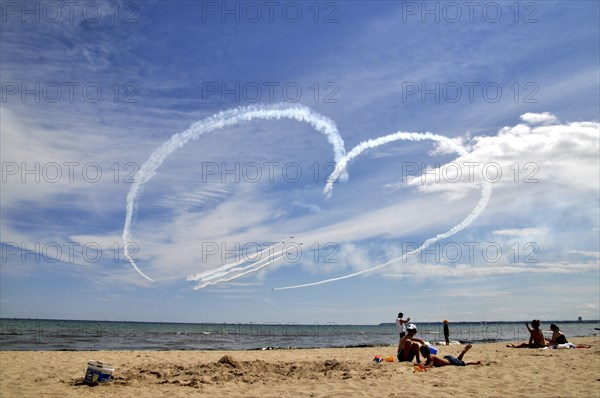 Airplanes draw heart in the sky and fighter jets fly through it