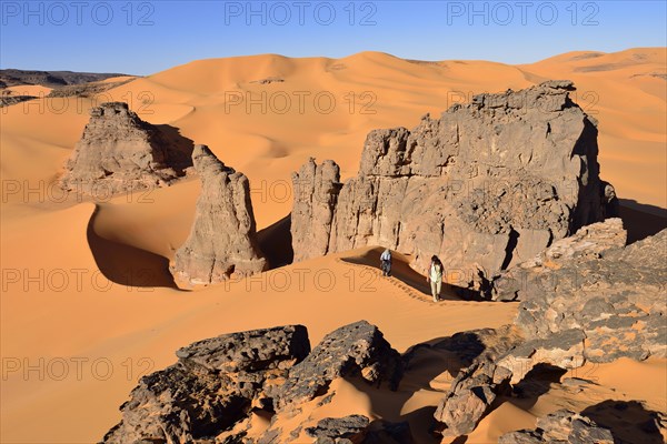 People hiking in the sand dunes and rocks of Moul Naga