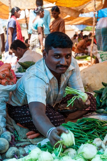 Cheerful vendor promoting kohlrabi