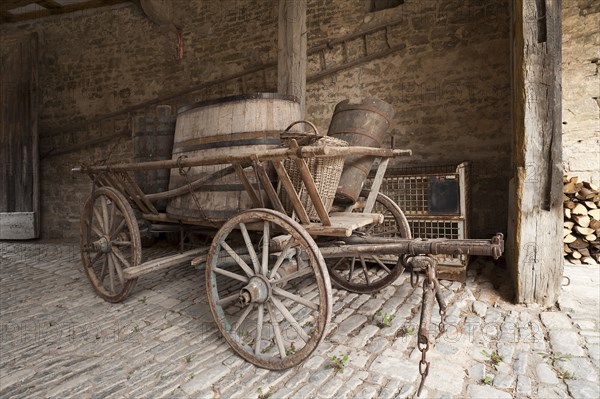 Old hay cart with wine barrels in the courtyard of a wine press