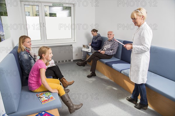 Receptionist calling for the next patient in the waiting room of a dental office