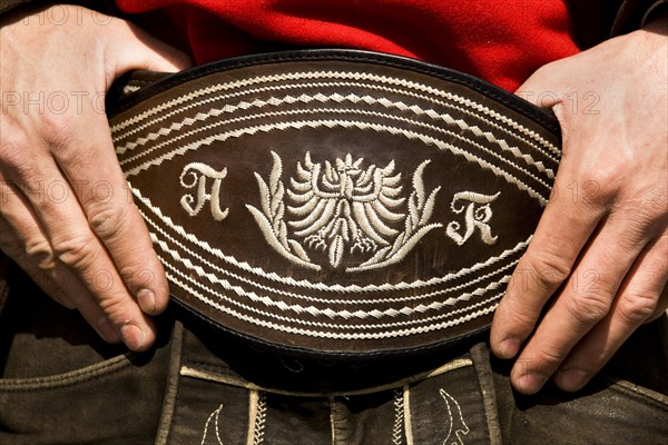 Man holding his traditional belt with both hands
