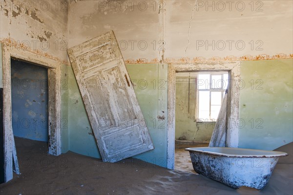 Wind-borne sand in a house of the former diamond miners settlement that is slowly covered by the sand of the Namib Desert