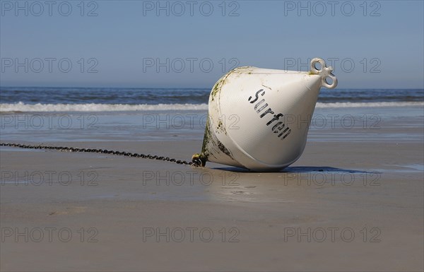 Buoy marked 'Surfen' lying on the beach
