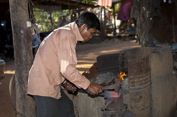 Blacksmith forging red-hot iron in a forge