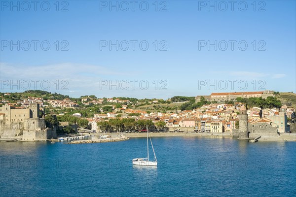 Sailboat in the harbor with Chateau Royal and Notre-Dame-des-Anges church at the back
