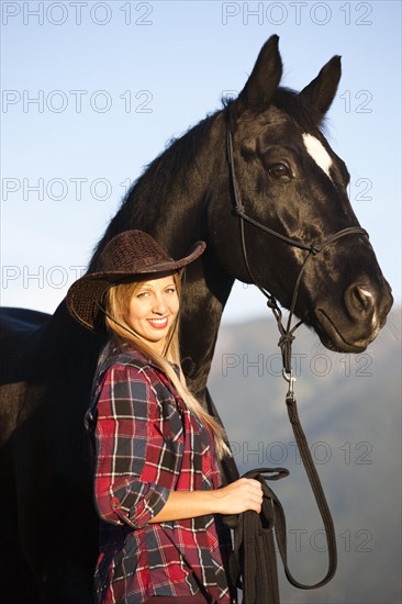 Young woman with a black Hanoverian horse