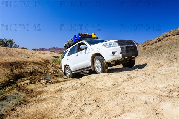 SUV driving through the mud of the Huab River