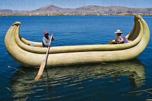 Two local in a traditional rowing boat of Totora reed on Lake Titicaca