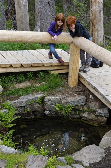 Two children at the source of the Warm Vltava river in the Sumava National Park near Kvilda