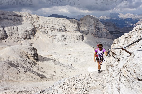 Mountain climber ascending Cunturines-Spitze Mountain in Fanes-Senes-Prague Nature Park