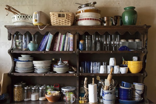 Messy shelves in kitchen full of cookbooks