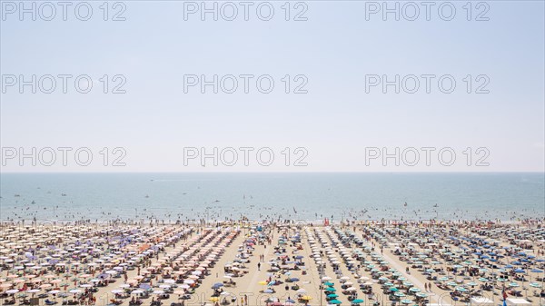 View of a beach with sunshades and sun beds