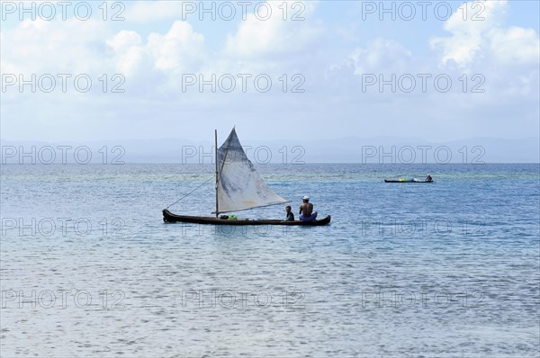 Kuna Indians in a dugout canoe with a sail