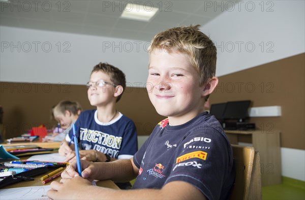 Children sitting in a primary school class during a drawing lesson