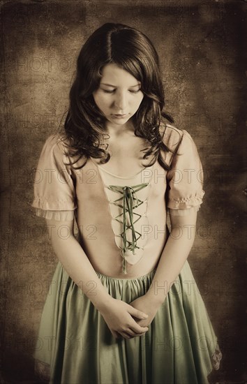 Girl wearing an old-fashioned dress looking sad