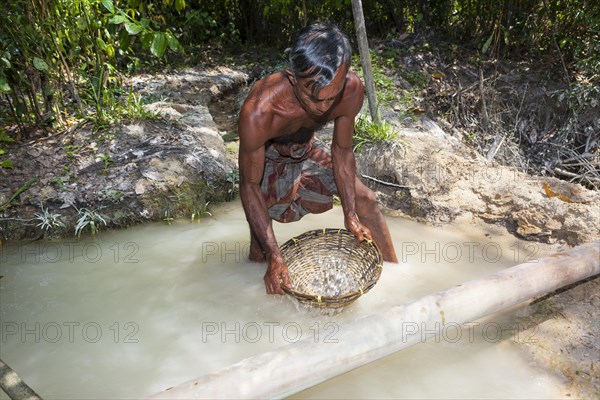 A labourer washing sand to win moonstones