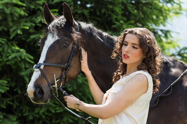 Young woman standing beside a horse