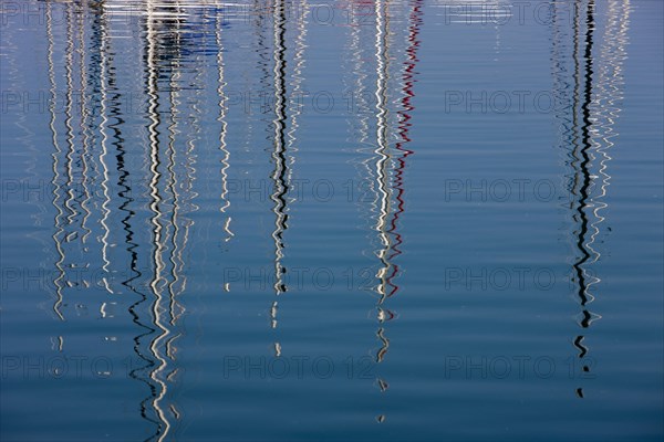 Boat masts reflecting in the sea