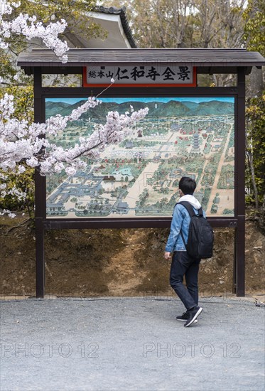 Tourist in front of an information board with map of the Ninna-ji temple complex