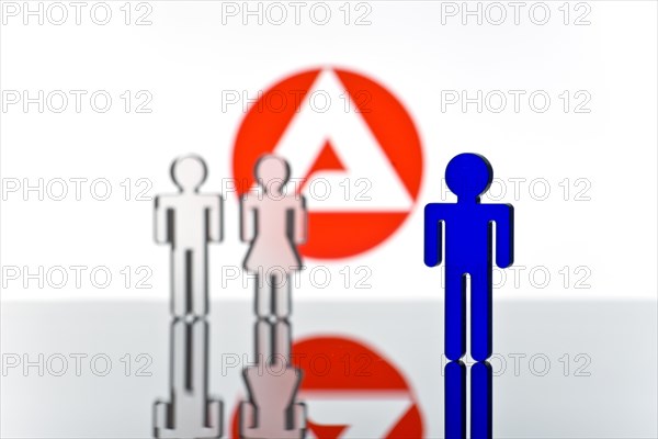 Three figures standing in front of the logo of the German employment agency