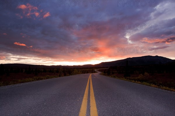 Denali Park Road with atmospheric clouds at sunset