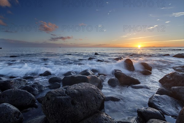 Sunrise at a beach with large rocks