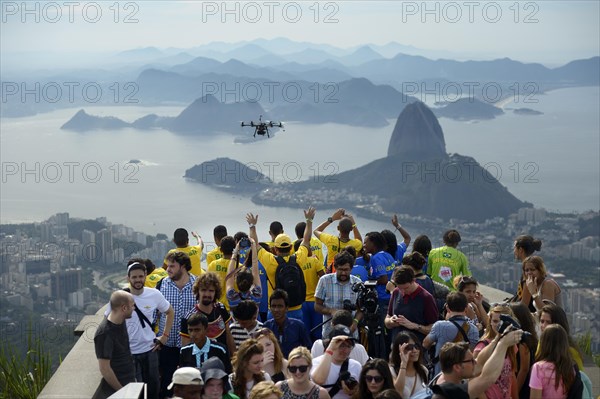 People cheering in the direction of a drone with cameras