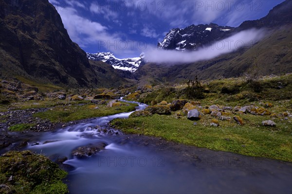 Mountain stream with the peaks of El Altar or Kapak Urku